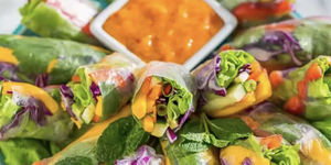 vegetable spring rolls surrounding mango dipping sauce