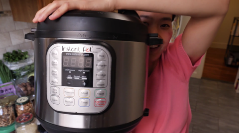june holds her moms instant pot with a smile