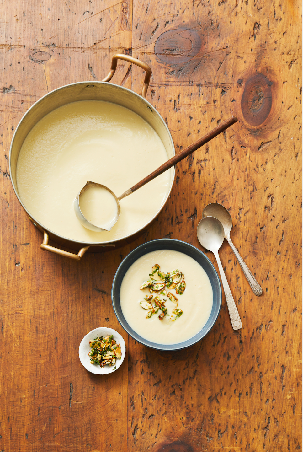 creamy cauliflower soup with almond thyme gremolata in a soup bowl