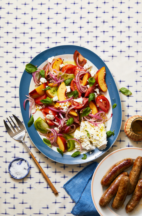 tomato, peach, and basil salad on a blue plate
