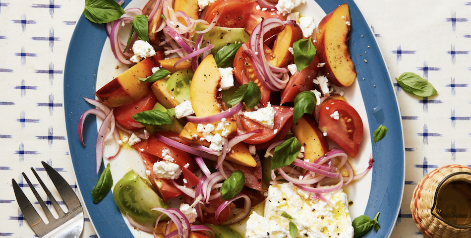 tomato, peach, and basil salad on a blue plate