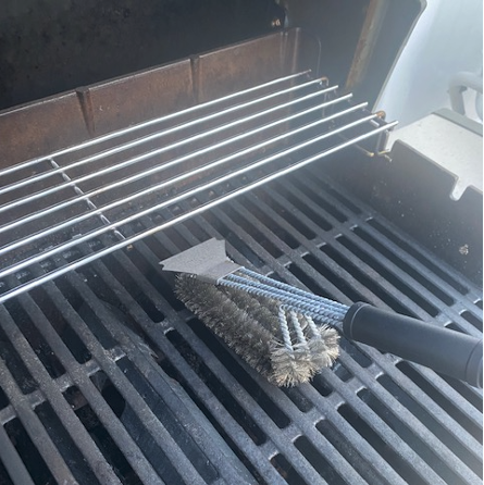 grill brush on the grill during testing, one of good housekeeping's best grilling accessories