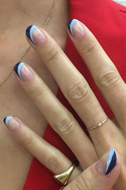 a clear manicure with two different shades of blue, light blue and navy blue, on the top of the nail