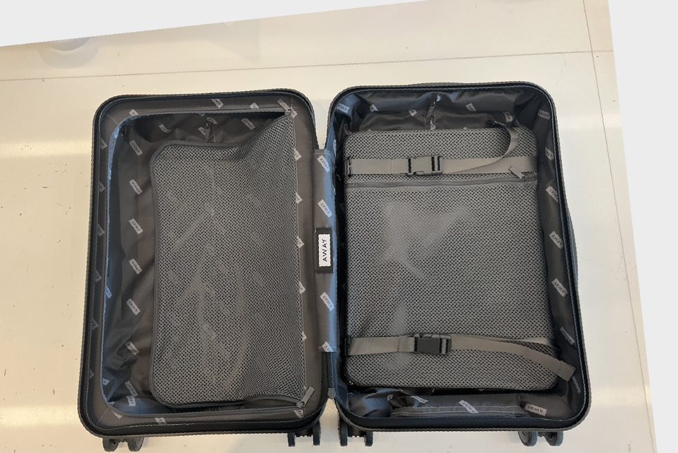 an empty away carry on laid open flat on a white table, good housekeeping's luggage review