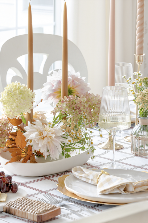 a thanksgiving table with a white tablecloth and beige accents