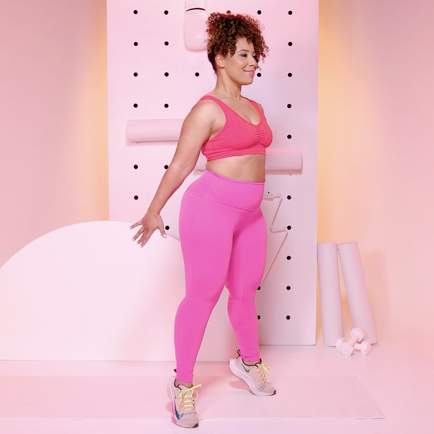 Young beautiful fit sporty female model pose in micro pink tight