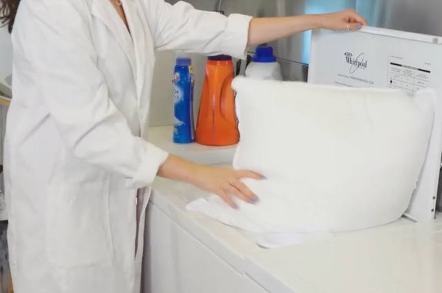 a good housekeeping analyst putting a pillow in the washing machine, good housekeeping's testing for the best pillows