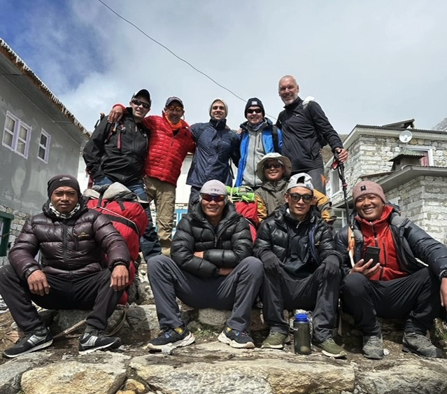 the hikers, sherpas, and porters pose for a photo