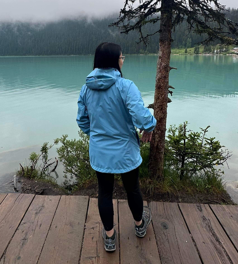 a consumer tester wearing a blue raincoat on a hiking trip