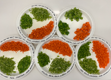 overhead shot of chopped peppers carrot and celery on labeled plates