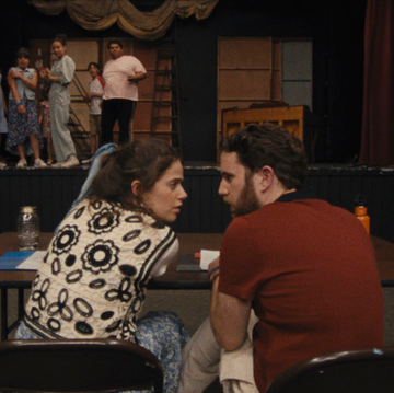 a man and woman sitting at a table in front of a group of people