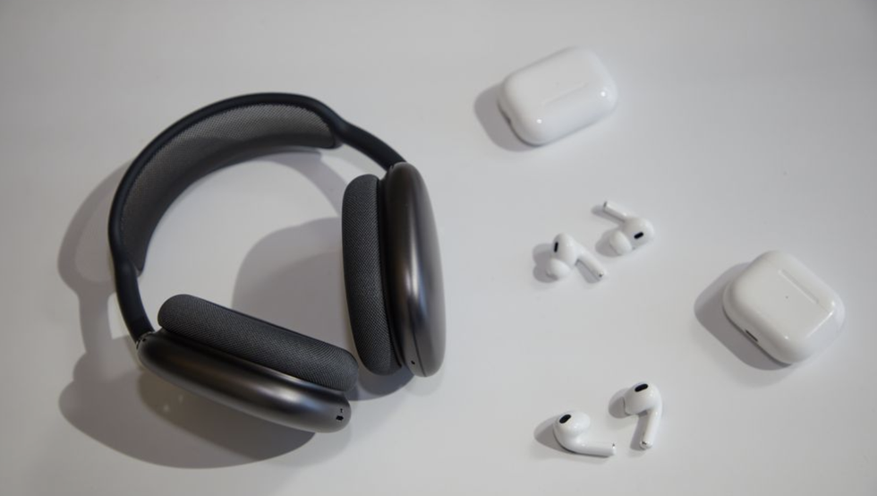a pair of black headphones and 2 pairs of white apple airpods