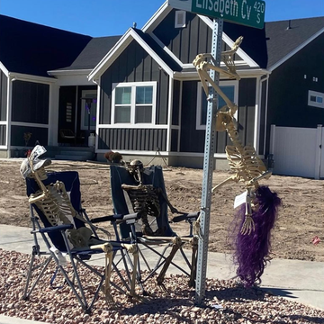 a group of people sitting at a table outside a house a group of people sitting at a table outside a house