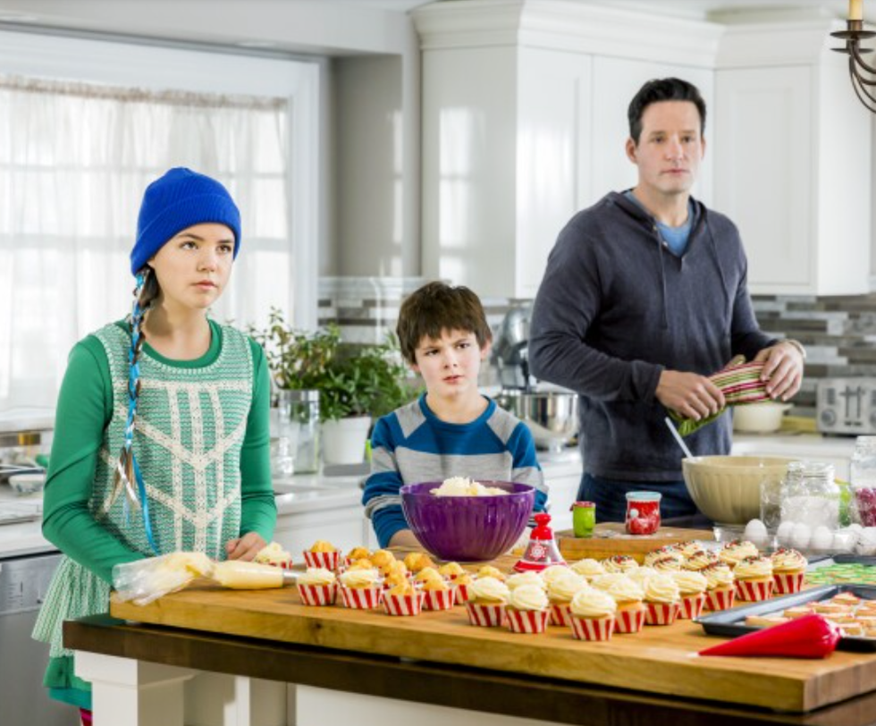 a group of people standing around a table with food on it