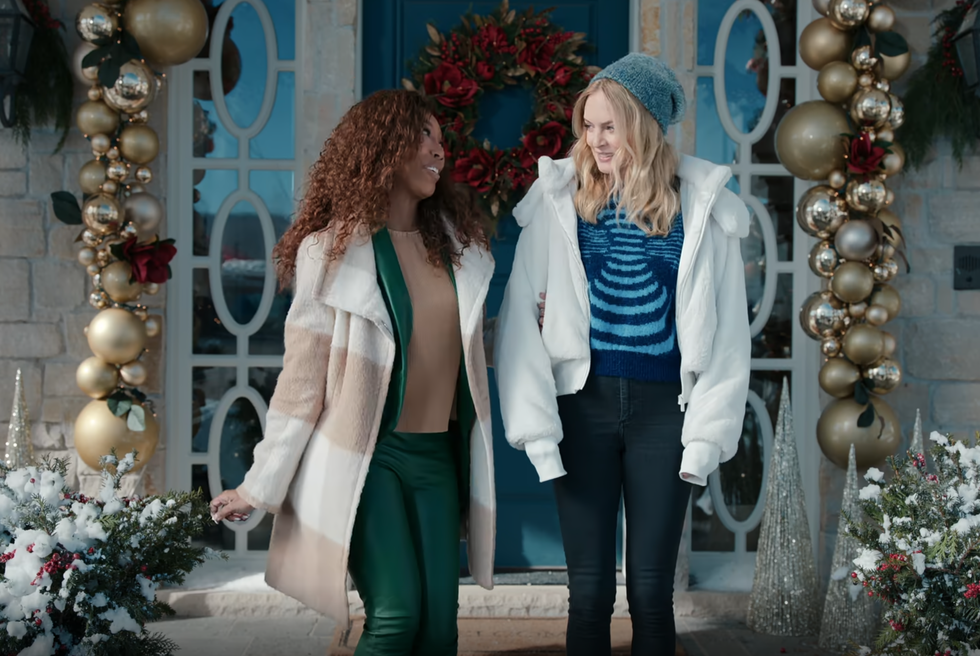 two women in front of house decorated for christmas