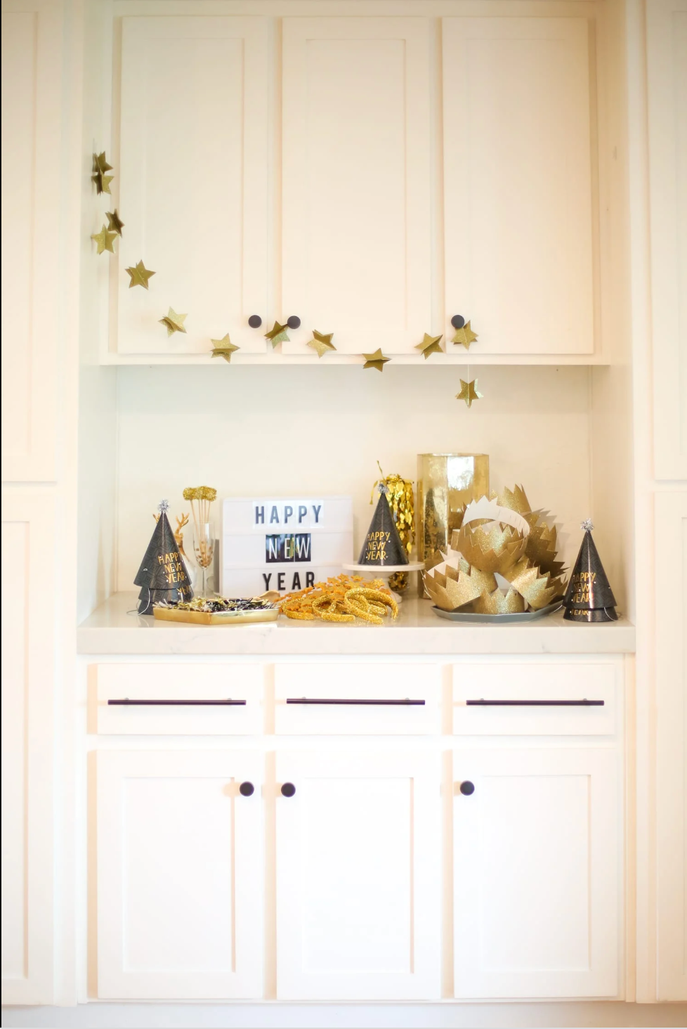 a white cupboard with a collection of party hats and crowns displayed on it