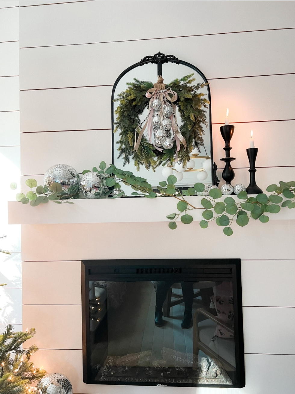 a fireplace with a discoball wreath hanging from it