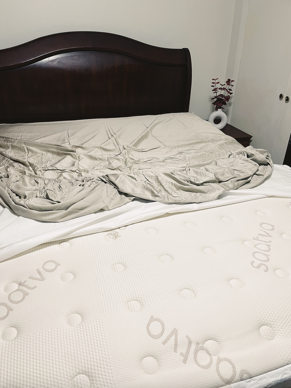 uma cama com um lençol branco
