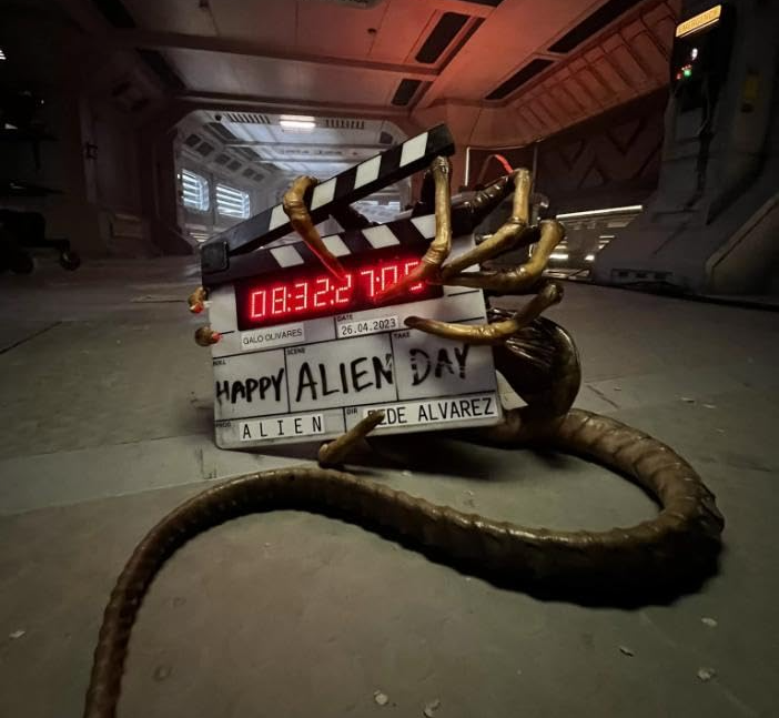 a film set with an alien hand wrapped around a board