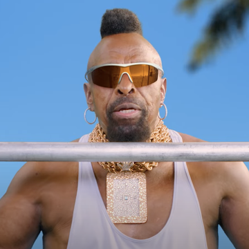 a person with a beard and sunglasses holding a bar