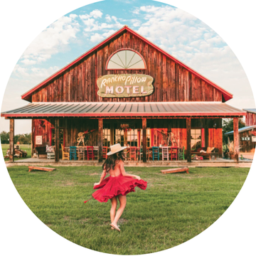 a girl in a red dress dancing in front of rancho pillow motel