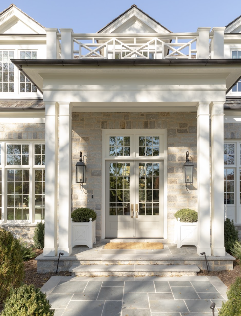 a white house with a large front door and a stone patio