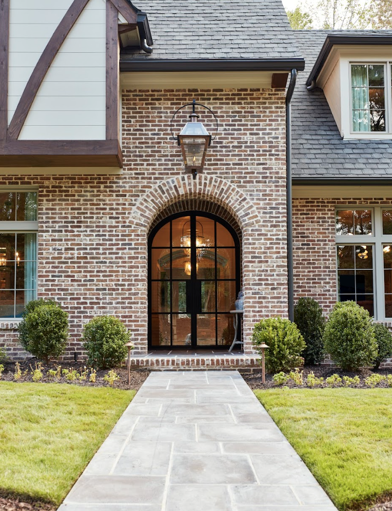 a brick house with a large front door and a stone walkway