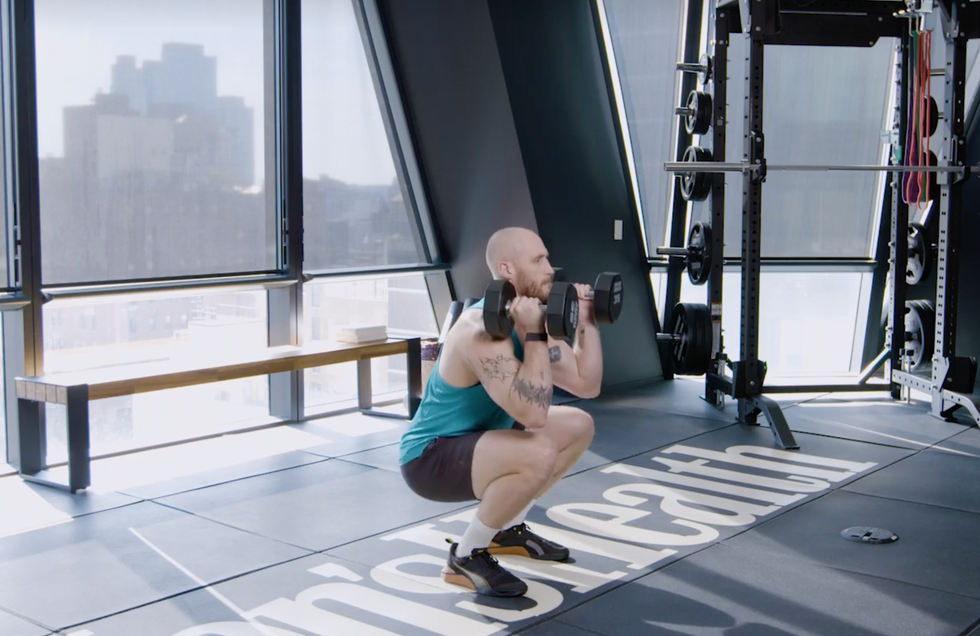 a person sitting on a bench taking a picture of himself in a mirror