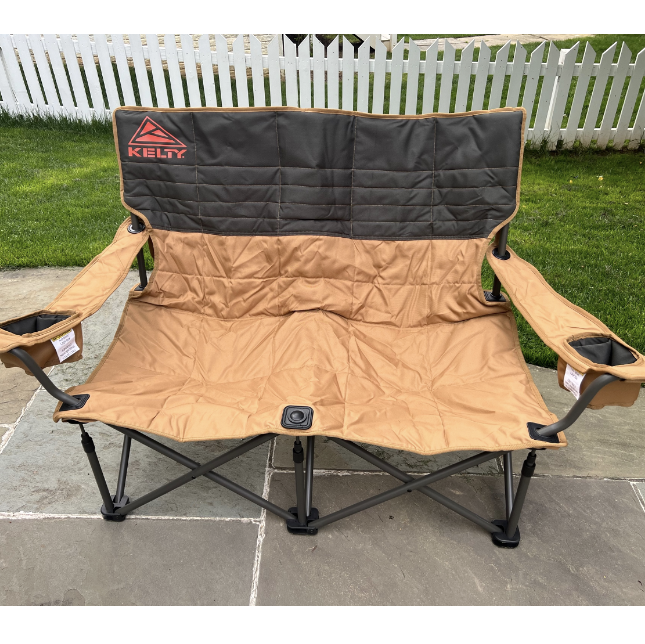 a brown two seater camping chair on the sidewalk, kelty low loveseat
