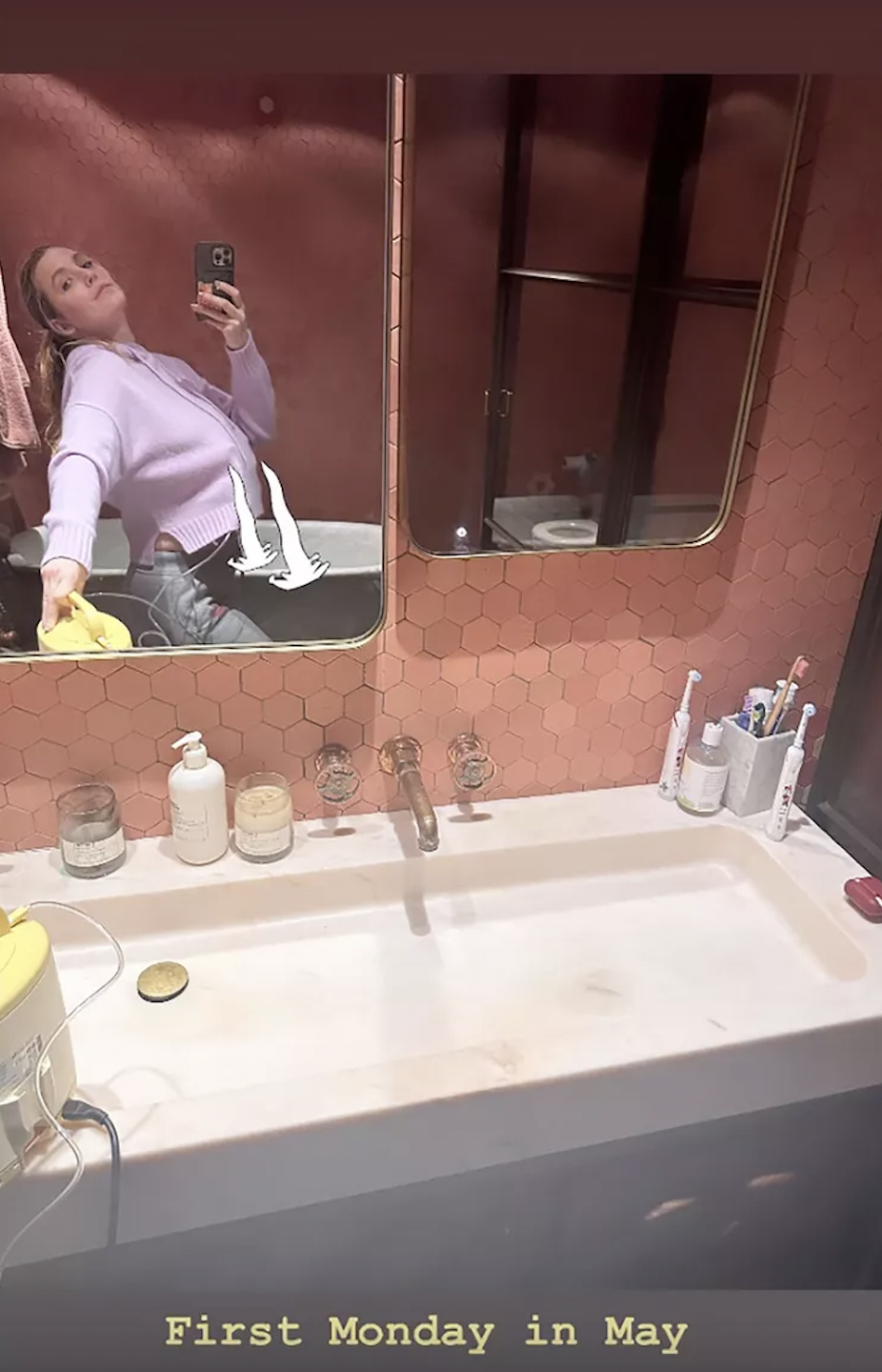 a person taking a selfie in the bathroom mirror