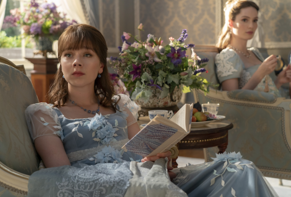 a girl sitting on a couch reading a book