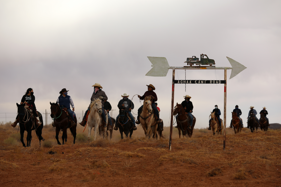 group of people on horseback approaching a directional sign