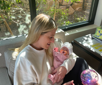 person holding a baby doll in a living room setting