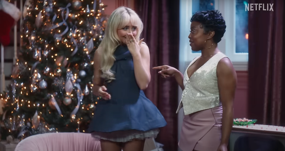 two women engaging in conversation in a festive indoor setting