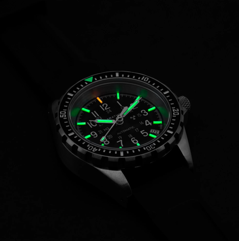 a closeup of a luminous wristwatch with a black background