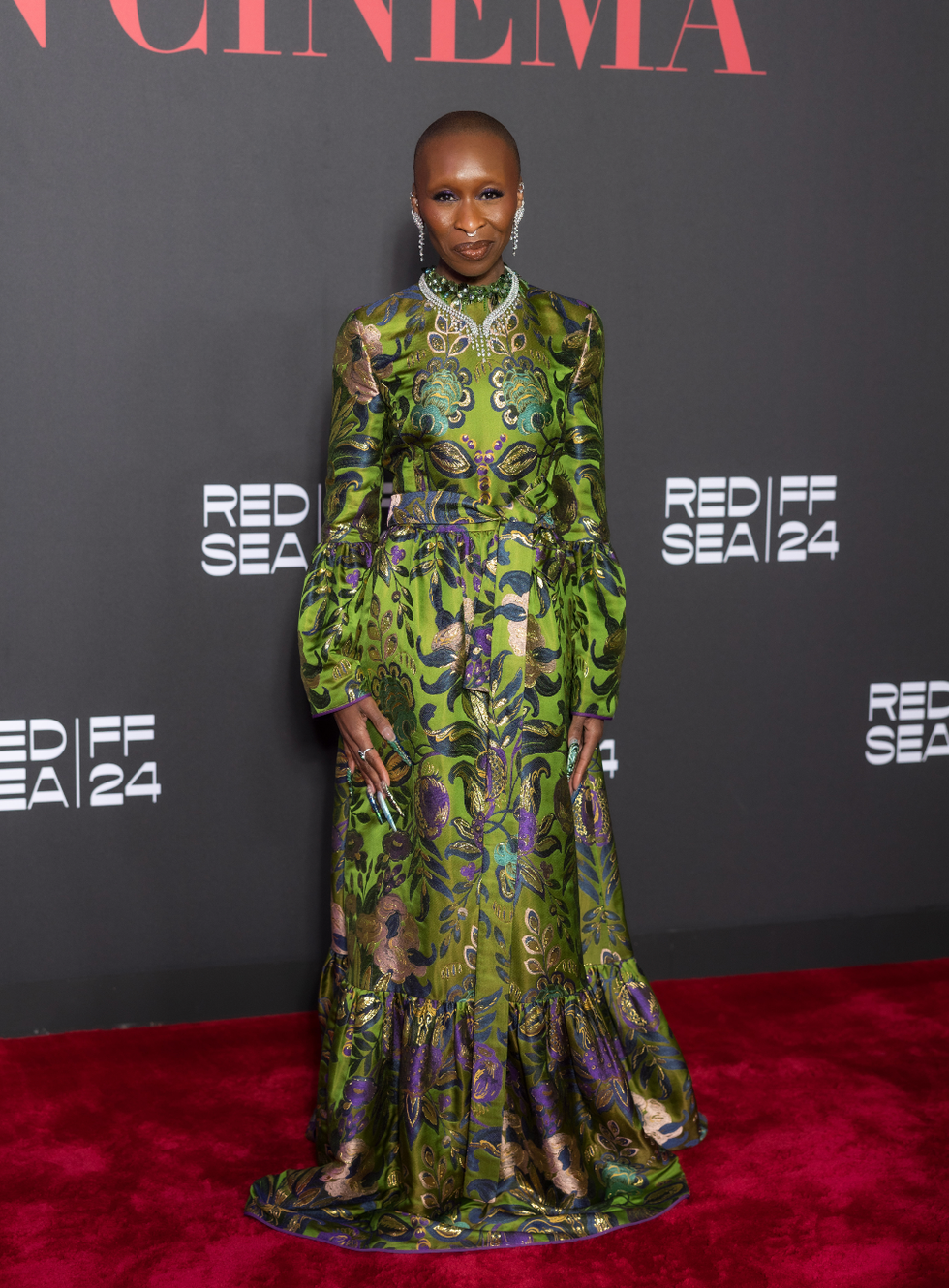 person wearing a vibrant green floral dress at a film festival event