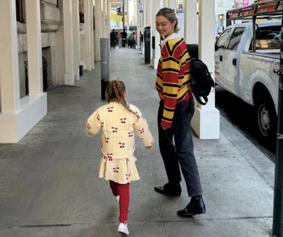 adult and child walking on a city sidewalk