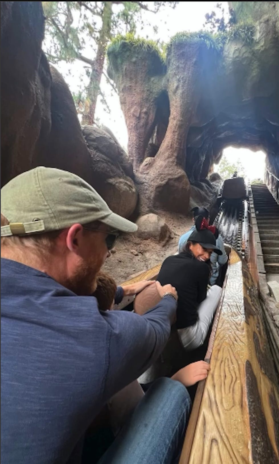 des individus parcourant une attraction de type « canal à bûches » à travers un tunnel rocheux