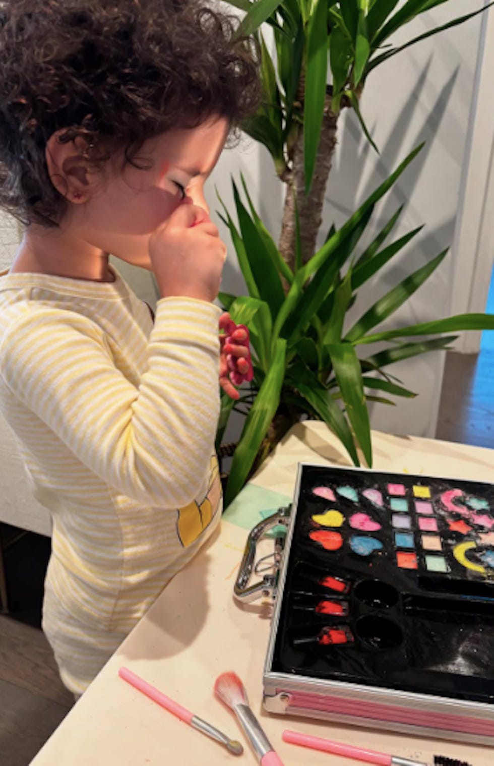 child playing with a makeup kit