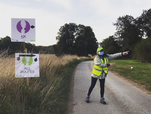 High-visibility clothing, Road surface, Asphalt, Workwear, Grass family, Signage, Flag, Prairie, Sign, Trail, 