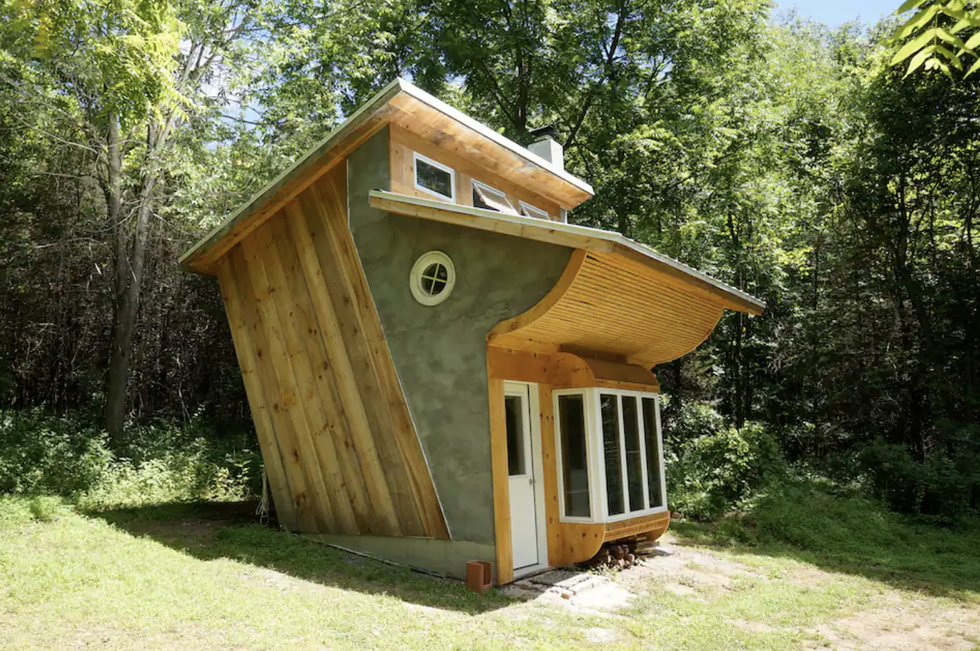 Rustic tiny house has a spacious interior and a balcony up top