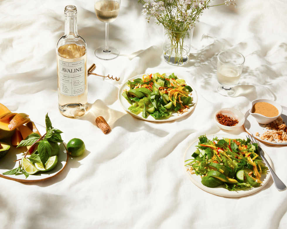 two salads next to a bottle of avaline wine