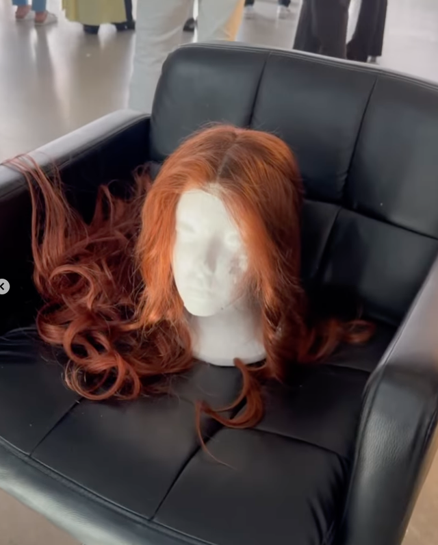 a red wig on a mannequin head