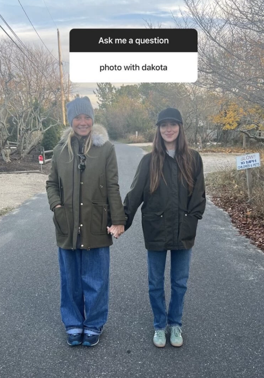 a man and woman standing on a road with a sign above them