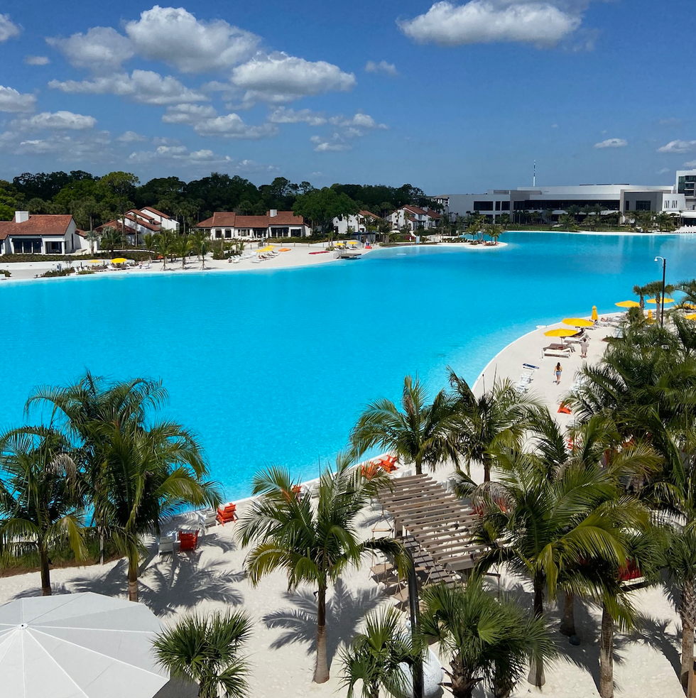 a pool with palm trees and buildings