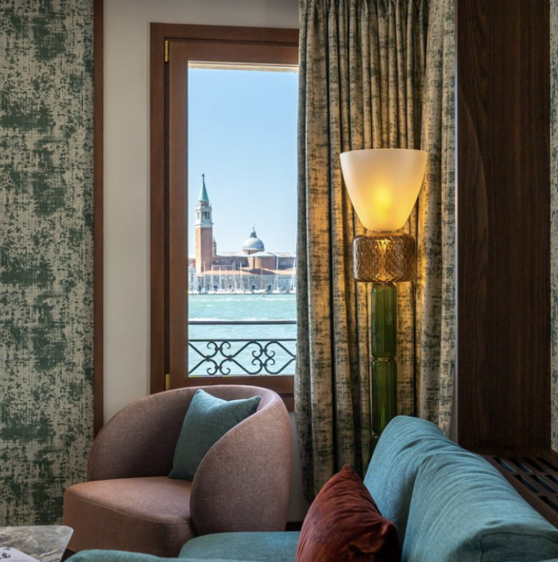 a chair and a lamp in a room with a view venice from ca di dio