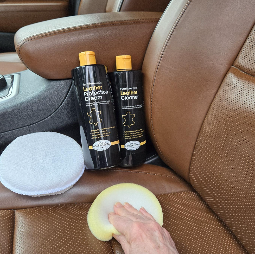 hand using leather cleaner inside a car