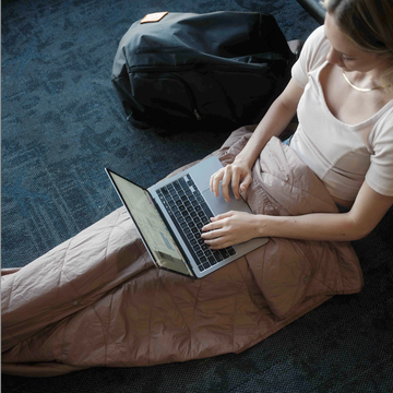 a girl sitting on the floor using a laptop