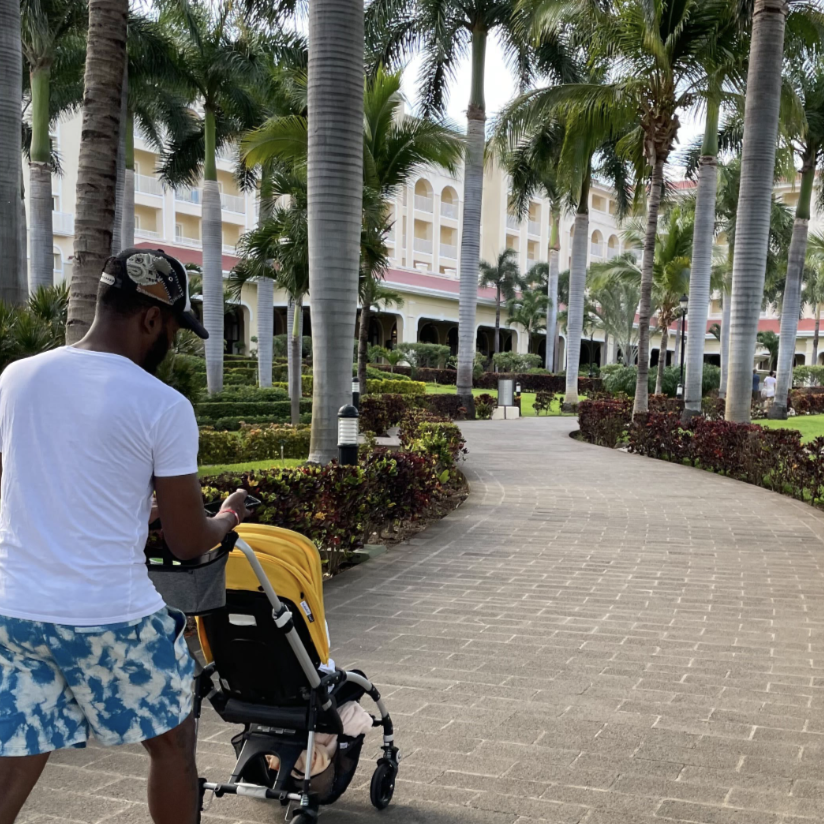 a dad pushes a bugaboo stroller at a resort, part of a good housekeeping story on the best travel strollers