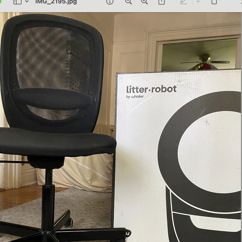 a litter robot shown next to a desk chair for size